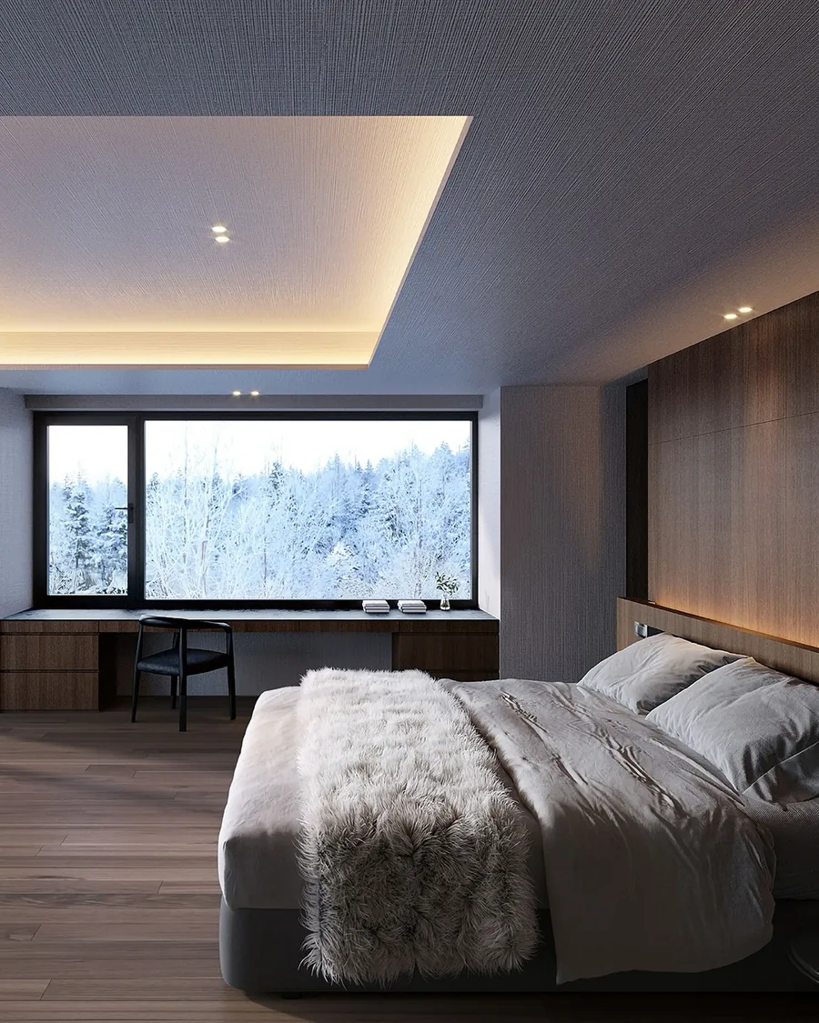 Bedroom with a picture window onto snowy trees
