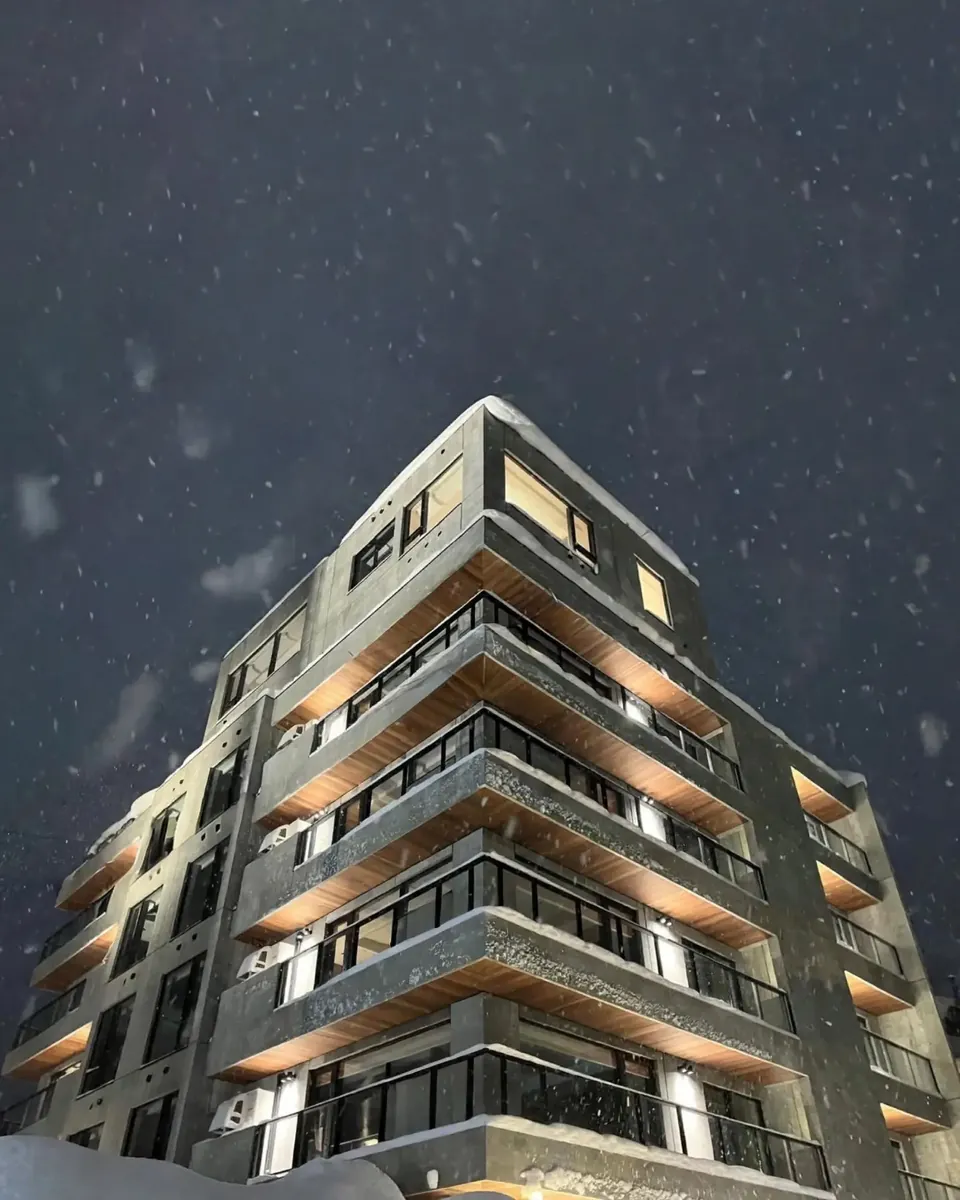 Powder Loft lit at night in falling snow